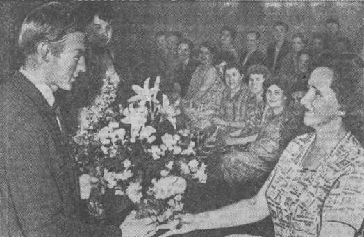 Н. Олялину от земляков работник кинотеатра имени Горького А. Бутышева подносит цветы