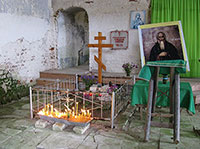 Интерьер Воздвиженской церкви Симоно-Воломской пустыни (юго-восточная часть). Надгробие преподобного Симона Воломского. Справа – образ святого. Фото 2014 г.