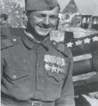 Николай Кузнецов, награжденный орденами и медалями, у своего орудия; на стволе «звездами» отмечены подбитые танки фашистов
